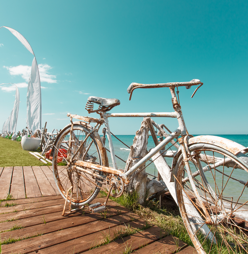 Scorcio del Guna Beach Club con una bicicletta decorativa e il mare sullo sfondo